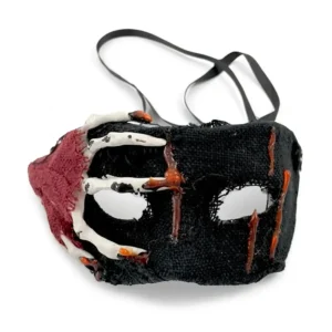 Antifaz de gasa negra con mano esquelética de plástico en un lateral y gotas de sangre de silicona para Halloween de Disfraces Lucero.