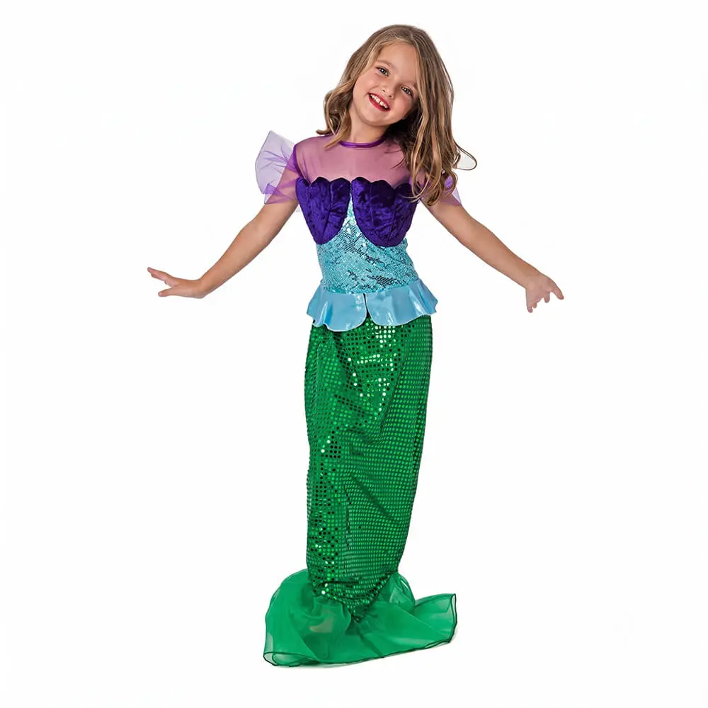 Niña de frente sonriendo con los brazos abiertos luciendo el disfraz de sirenita infantil con vestido largo verde con textura de escamas brillantes y corpiño de conchas moradas de la tienda Disfraces Lucero.