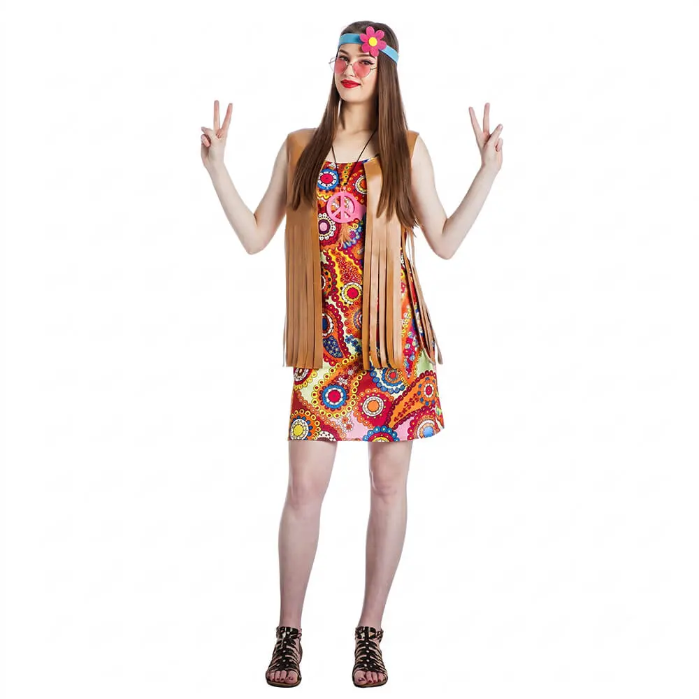Mujer posando de frente con gesto alegre sonriendo y luciendo el disfraz de chica hippie para adulta de la tienda Disfraces Lucero, compuesto por un vestido corto psicodélico con mangas acampanadas, chaleco marrón de flecos y cinta elástica en el pelo.