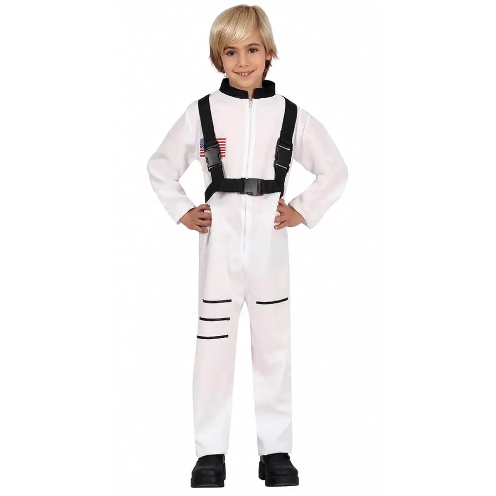 Niño rubio sonriendo de frente con las manos en las caderas luciendo el disfraz de astronauta infantil de la tienda Disfraces Lucero, que consiste en un mono blanco de manga larga con cremallera frontal, cuello alto negro, arnés negro con hebillas y bandera de EE.UU. en el pecho.